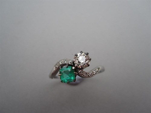 Lot 199 - An emerald and diamond two-stone crossover ring