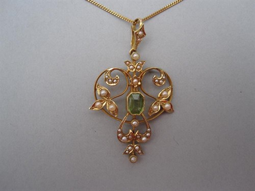 Lot 160 - An Edwardian art nouveau peridot and seed pearl pendant