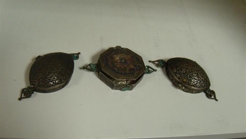 Lot 706 - A 19th century Persian partially-enamelled amulet case and a pair of others in silver