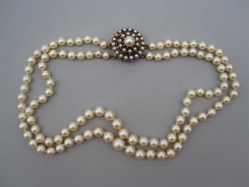 Lot 129 - A two strand cultured pearl necklace with pearl set clasp