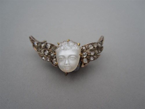 Lot 222 - An antique carved moonstone and diamond cherub brooch