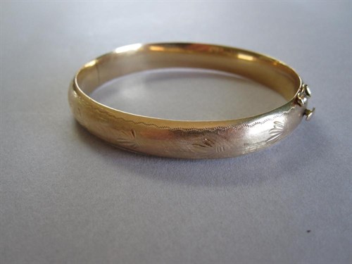 Lot 114 - A hinged bangle with bright cut decoration